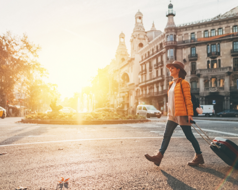 Woman with suitcase walking at the street in Barcelona