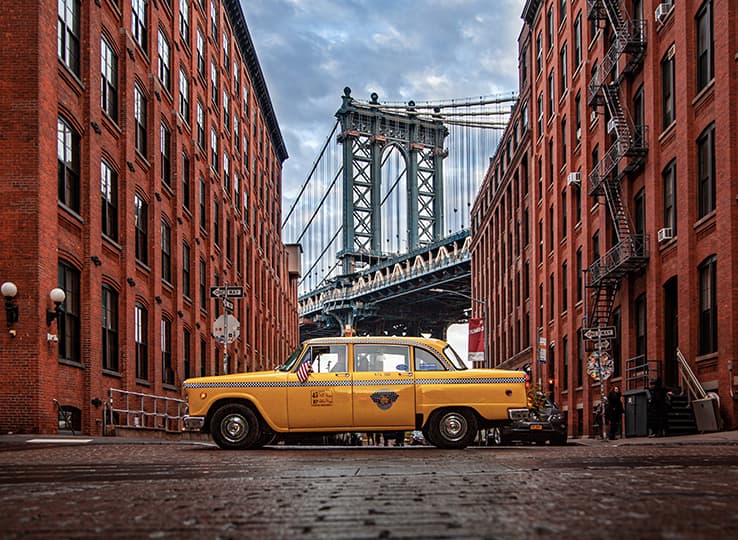 Taxi in New York City with Brooklyn bridge in the background